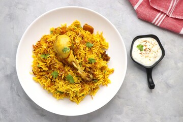 Chicken Biryani/murg Pulao. Garnished with fried onion & chopped coriander. Biryani raita is a famous Spicy non vegetarian dish of India. Chicken cooked along with Basmati rice & spices. copy space.