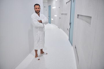 Fototapeta premium Good-looking young man standing in corridor of wellness center