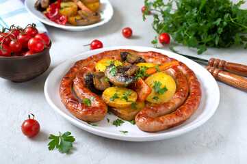 Tasty homemade grilled sausages with baked herb potatoes, mushrooms, cherry tomatoes and ketchup on a wooden background. Oktoberfest snack. Summer picnic dish