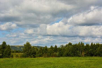 Fototapeta na wymiar Beautiful summer landscape, green hills, rain clouds in the sky