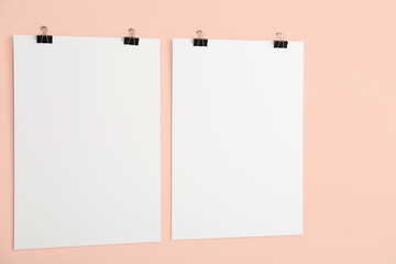 Blank posters hanging on color wall