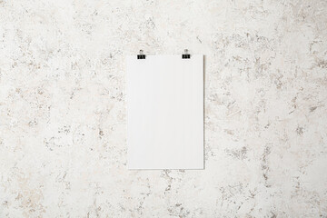 Blank poster hanging on light wall