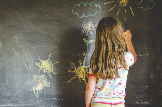 Child drawing on chalkboard