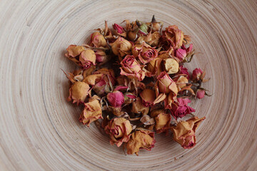 Vintage background. Roses in a wooden bowl. Dried buds.