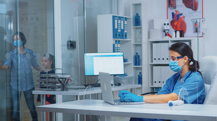 Obraz premium Mother and daughter coming at pediatrician consultation in medical office during coronavirus. Physician specialist doctor in medicine with protection mask providing health services in hospital clinic