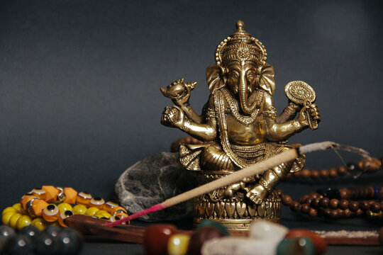 Table with occult attributes, top view. Ganesha figurine, stone rosaries, candles, aroma stick