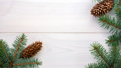 Christmas fir tree with pinecones on a white wooden board and copy space for your text. Banner.Flat lay