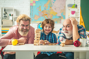 Little boy enjoy time with elderly grandfather and young father. Family tree. Jenga games for family.