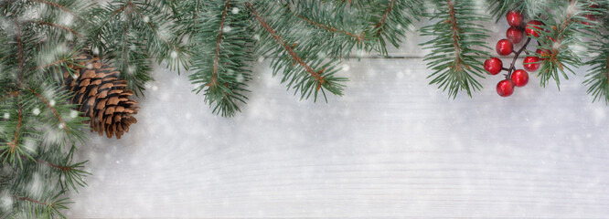 Fototapeta na wymiar Christmas New Year background with fir tree, pinecone, red berries and snow on a white wooden background. Copy space for your text. Banner. Flat lay