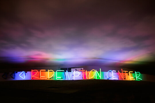 Neon rainbow sign that reads ""Redemption Center""