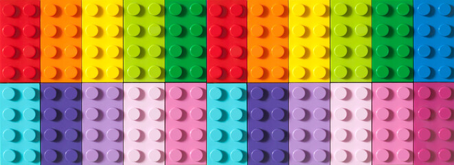 Many toy blocks in different colors making up one large square shape in top view. Toys and games....