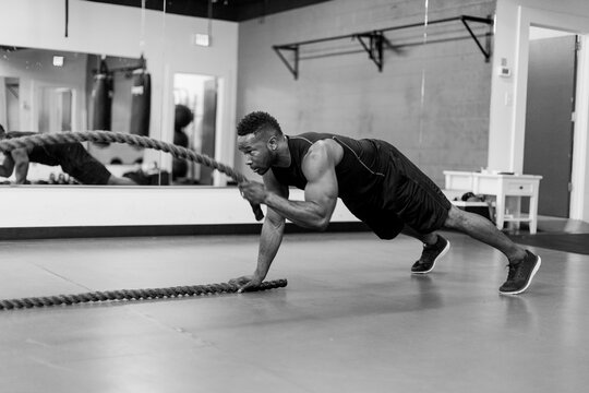 Fit And Muscular African American Athlete Working Out With Exercise Ropes