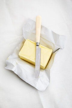 A full block of butter with a knife
