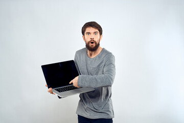 A man in a gray sweater with a laptop hands lifestyle technology communication internet work