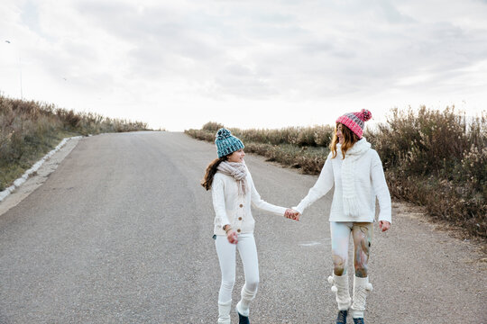 Mother and daughter walking together hand in hand