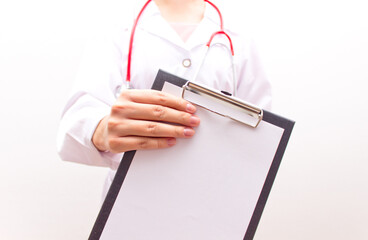 Female doctor showing blank clipboard. Selective focus. Mockup.