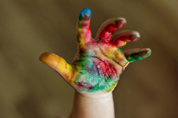 Child hands painted in colorful paints.
