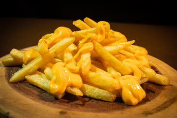 french fries with cheddar wooden background