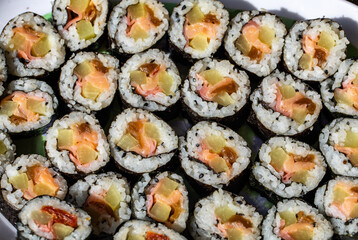 Top view of stack of Japanese sushi maki roll plate. Served in Japanese bar restaurant with chopstick