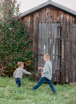 Brothers sword fighting with fuzzy weeds