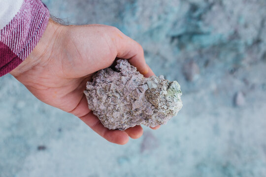 young man holding what looks like moon rock in hand