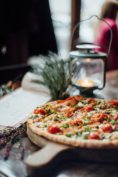 Pizza, lantern and menu, arranged on the rustic table