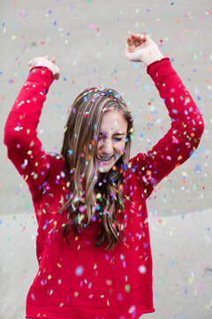 Beautiful teenage girl having fun with confetti