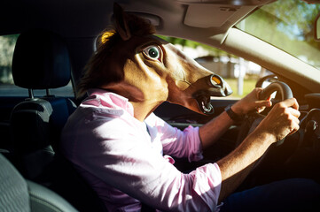 Man in disguise with a horse head driving the car