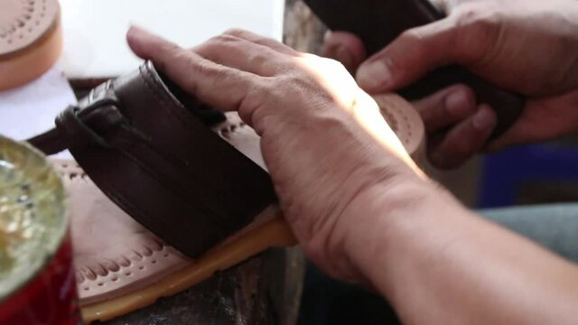 craftsman when making leather sandals manually in his garage, Batang Indonesia