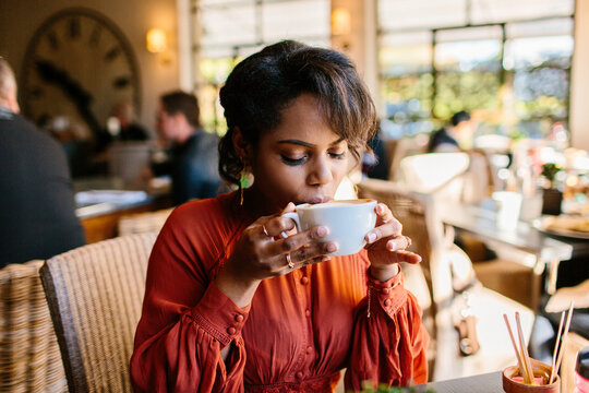 Beautiful woman sitting in a coffee shop sipping her latte