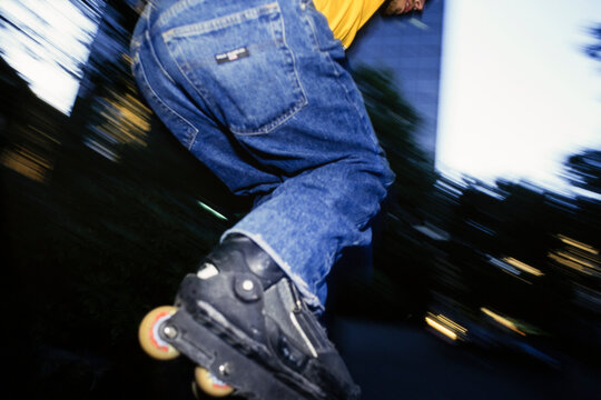 Man rollerblading and jumping over urban wall