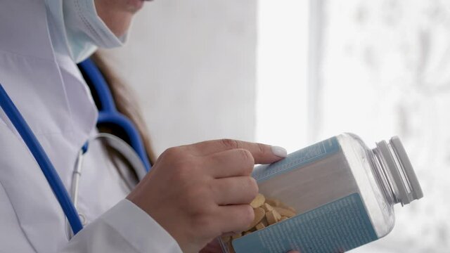 Doctor looking at pack of pills medication. Reads the composition of the pills.