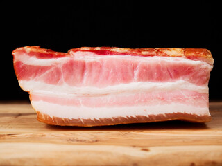 Smoked pork joint on a wooden cutting board. Traditional East European cuisine. Meat industry product.