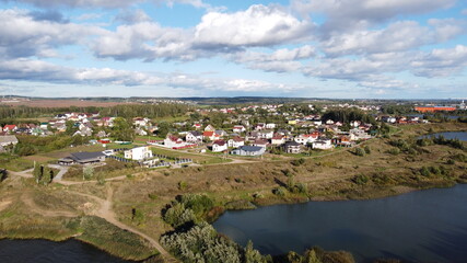 Fototapeta na wymiar Top view of suburban cottages and houses near a large summer lake