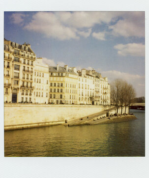 Polaroid Photograph Of People Enjoying A Sunny Day Along The Seine River In Paris France