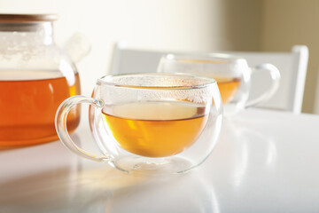 White table with glasses and pot with tea