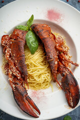 cooked sliced ​​lobster on a plate of pasta decorated with basil leaf vertical photo
