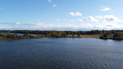 A view from a height of a beautiful calm shore of a forest lake