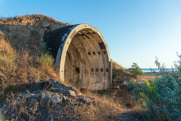 An old abandoned military tunnel, a semicircle of concrete inside a hill. side view