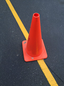 Traffic cone and yellow boundary line on road