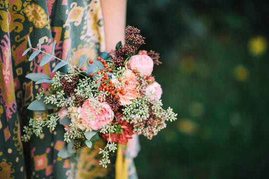 Woman holding a lovely bouquet of pink peonies and eucalyptus