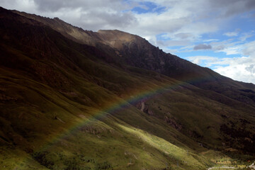 Rainbow over a green valley surrounded by mountains. Caucasus, Russia.