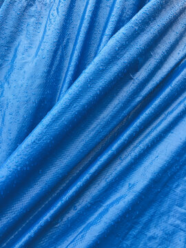 Close up of stretched blue tarpaulin covering industrial fishing equipement