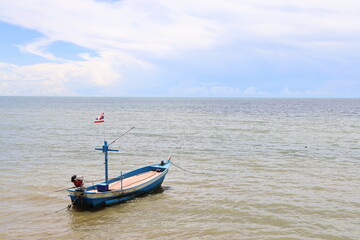 Naklejka na ściany i meble Fishing boat in the cloundy ocean