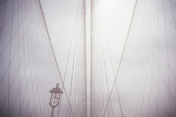 View of cables from Brooklyn Bridge with dense fog, NY, NY, USA