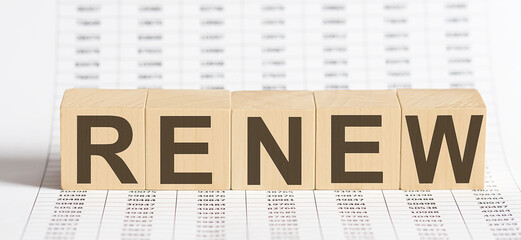 wooden cubes with letters RENEW on chart background