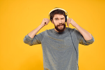 Man with headphones listening to music lifestyle technology studio yellow background