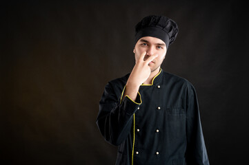 Pay attention or look at me concept with young male dressed in a black chef suit