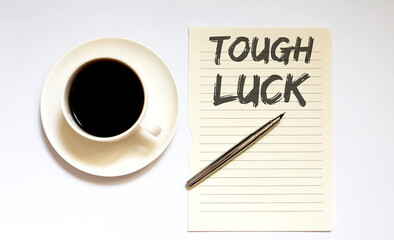 TOUGH LUCK - white paper with pen and coffee on wooden background