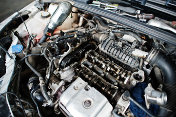 Obraz na płótnie Canvas Car repair and maintenance theme. Open hood engine in auto service.